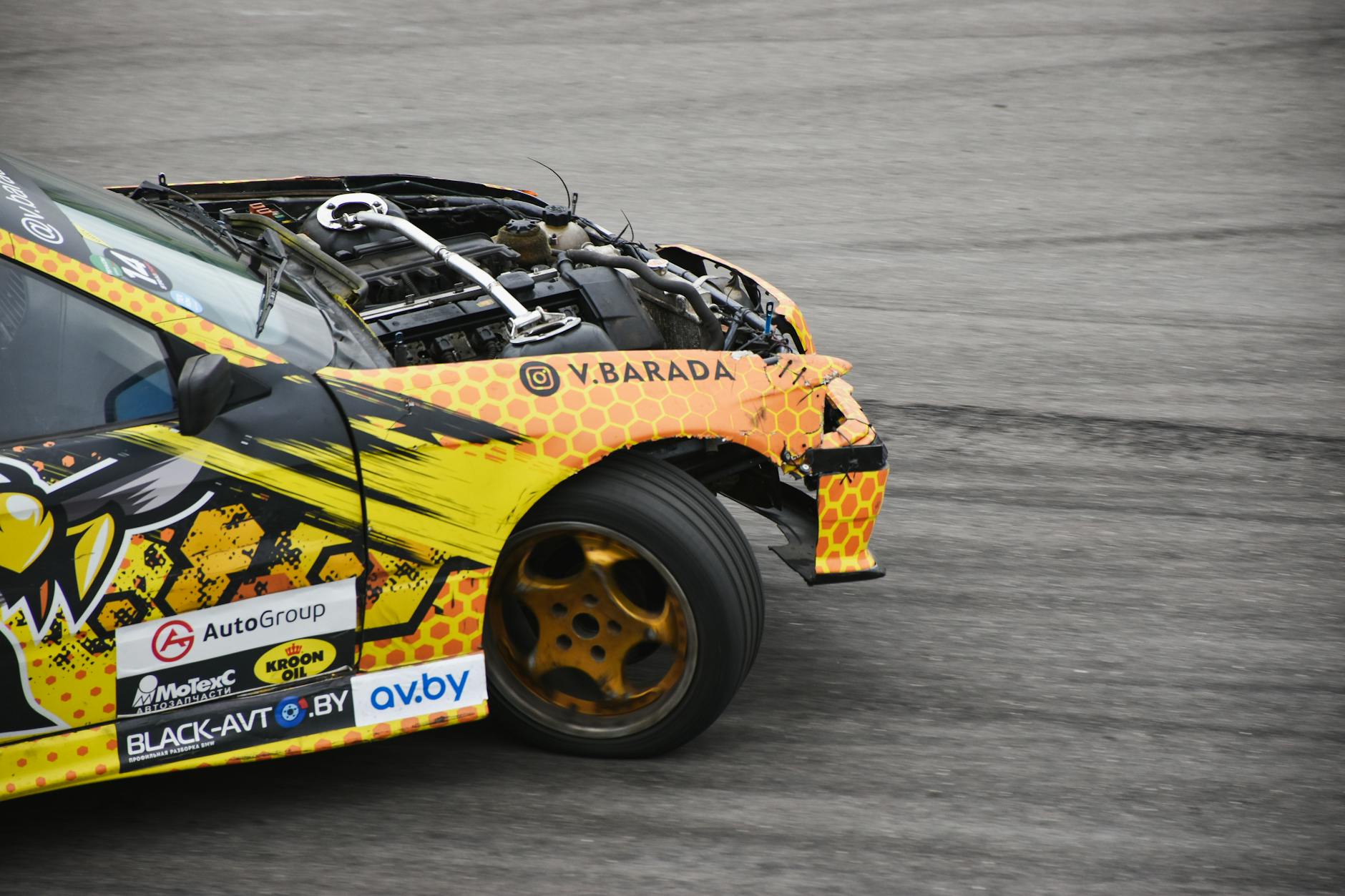 A vibrant stock car with visible engine damage after an auto racing crash, showcasing risk and misfortune.
